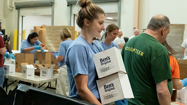 A volunteer carries boxes of Ben's Original rice